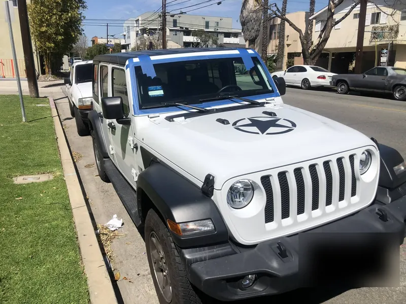 White Jeep Wrangler with a new windshield installed curbside in Los Angeles