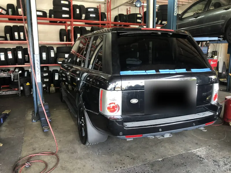 Black Range Rover with a newly installed rear windshield taped in place